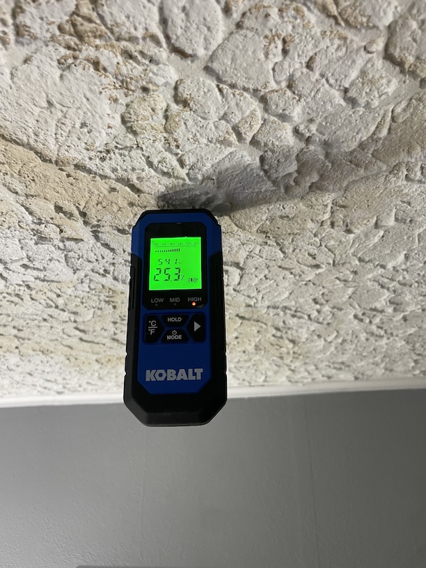 Image of a moisture probe inserted into a ceiling to identify if it is wet.  