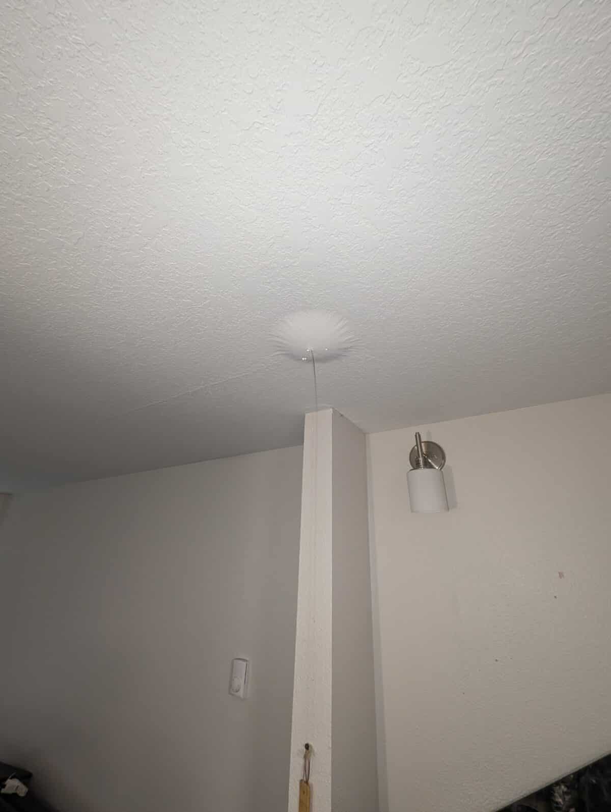 Water draining from a water bubble in the ceiling from a leaking pipe in the apartment above.