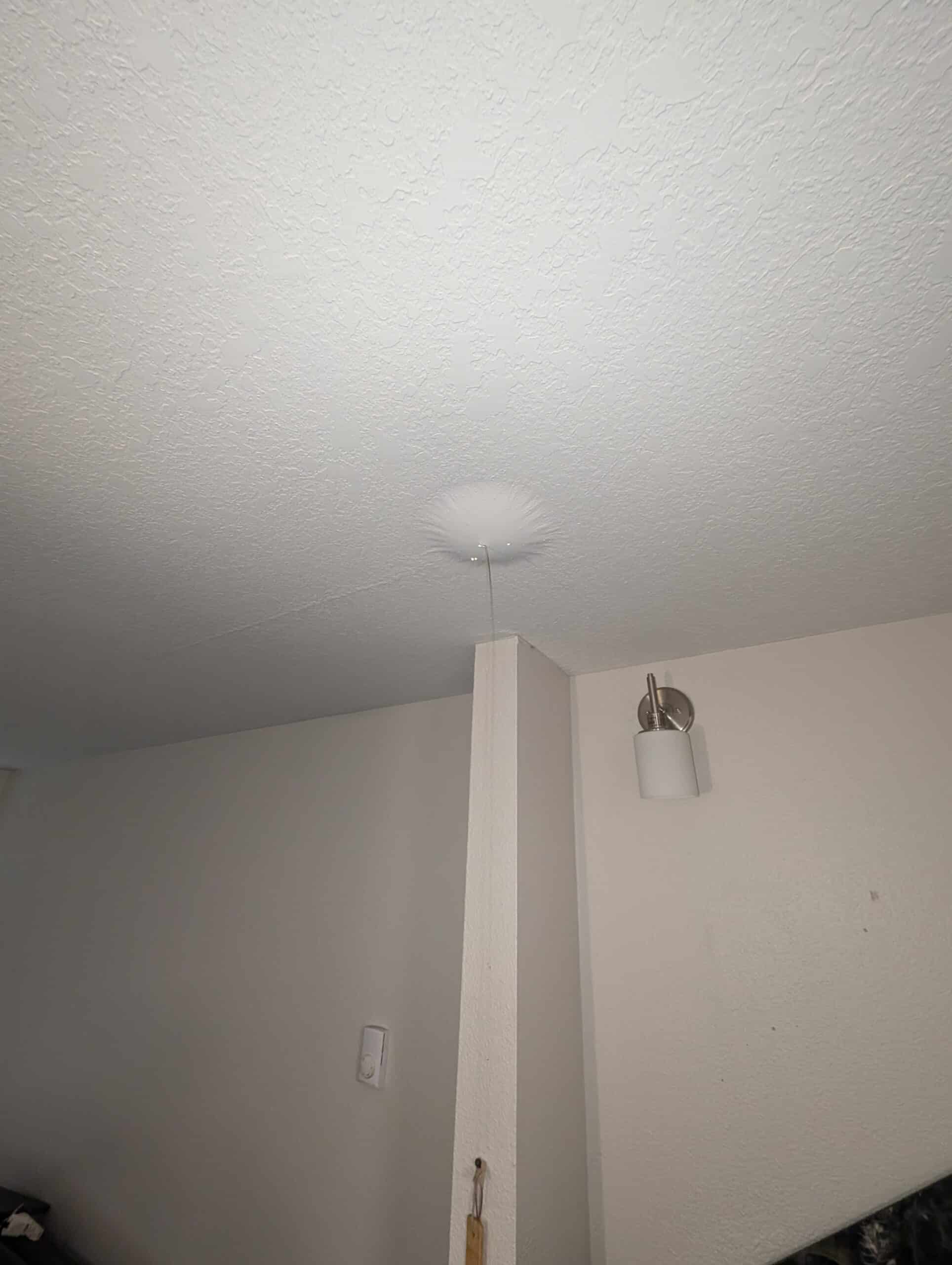 Water draining from a water bubble in the ceiling from a leaking pipe in the apartment above.